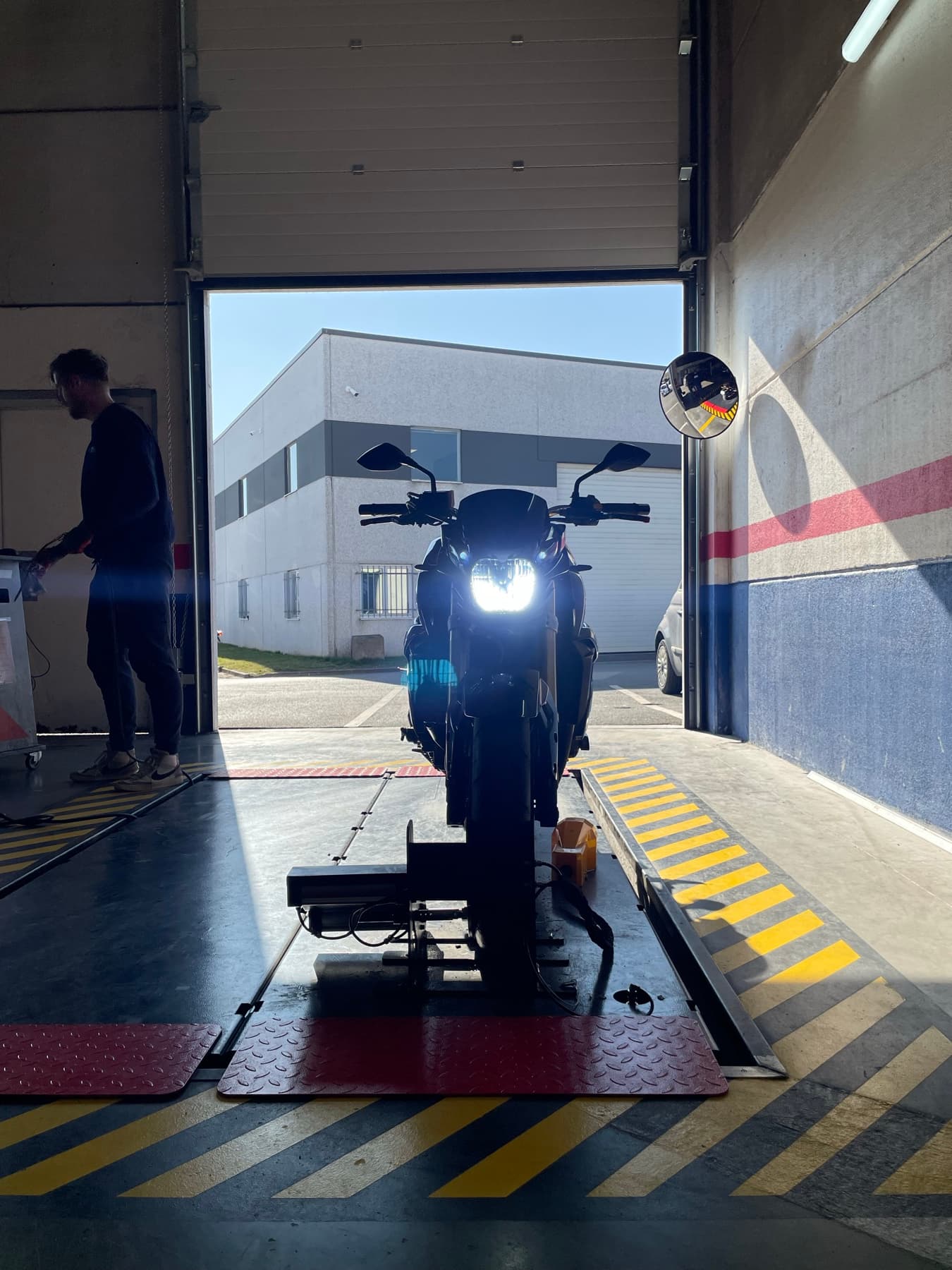Contrôle de l'éclairage d'une moto : le feu avant est allumé face à l'appareil de réglage